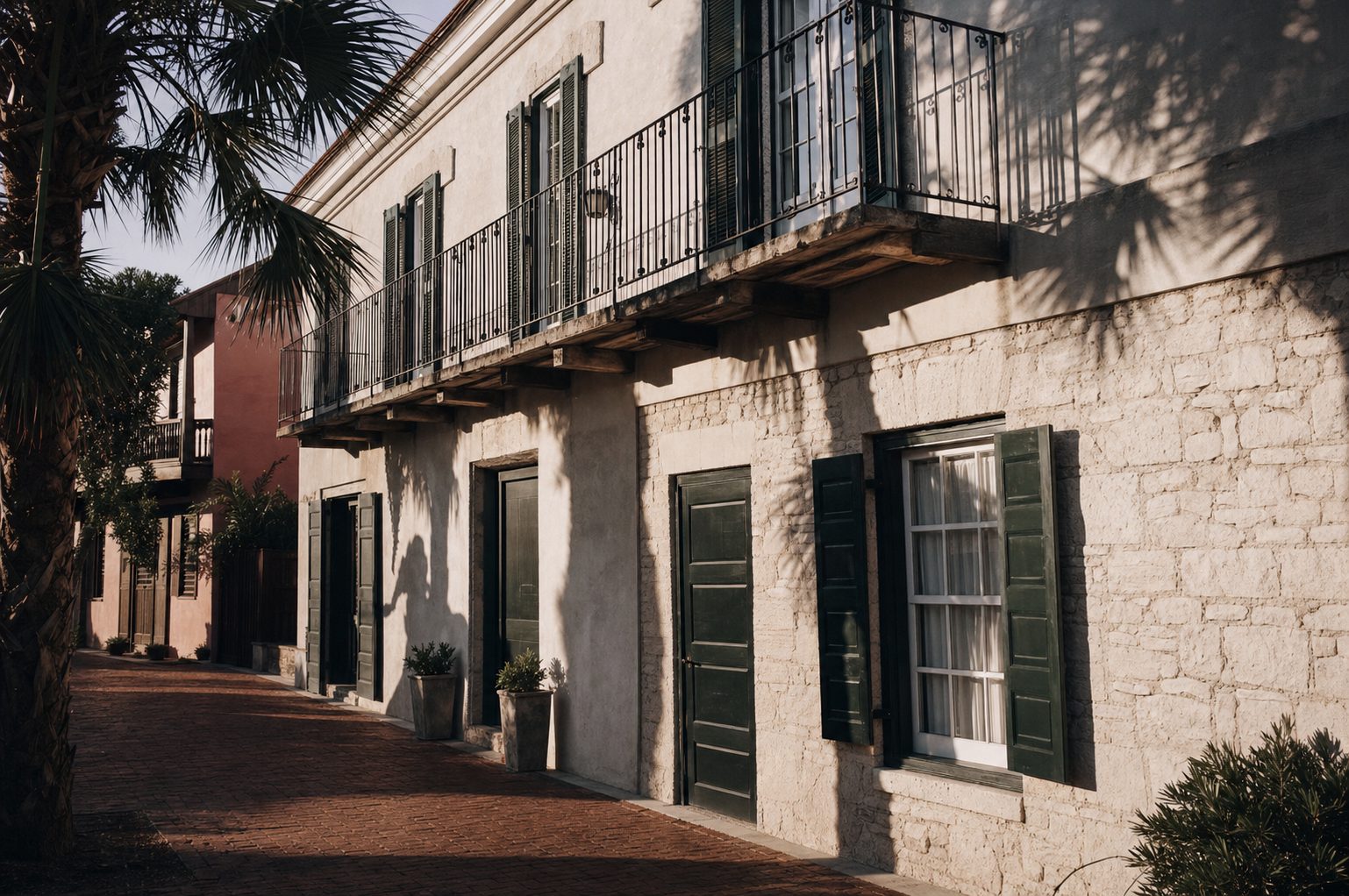 Coquina stone and stucco facade with dark green shutters and iron balcony in the St. Augustine historic district